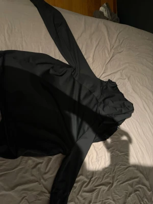 Svart hoodie från Peak Performance - Säljer en svart hoodie från Peak Performance i storlek M. Hoodien har en klassisk huva och är tillverkad i mjukt fleecematerial som känns riktigt skönt mot huden. Perfekt för dig som gillar en enkel och stilren look.