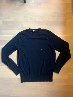Svart basic tröja från Uniqlo - En stilren svart tröja från Uniqlo med rund halsringning och långa ärmar. Tröjan har en enkel, klassisk design och är tillverkad i ett mjukt material som passar perfekt till olika outfits.