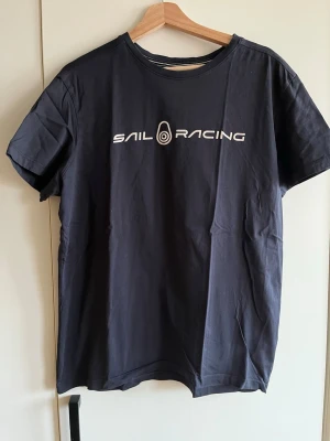 Mörkblå Sail Racing t-shirt - Snygg svart t-shirt från Sail Racing. Använd men i gott skick. 