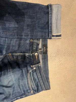 Mörkblå jeans från A.P.C. - Säljer ett par mörkblå selvedge jeans från A.P.C. i klassisk rak modell med fem fickor och snygga kontrastsömmar. Perfekta till sneakers eller boots. W30 L32
