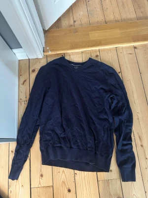 Mörkblå tröja från Race Marine - Mörkblå långärmad tröja från Race Marine med V-ringning. Tillverkad i mjukt och tunt material som passar perfekt för lager på lager. Klassisk och enkel design med ribbade muddar vid ärmslut och nederkant.