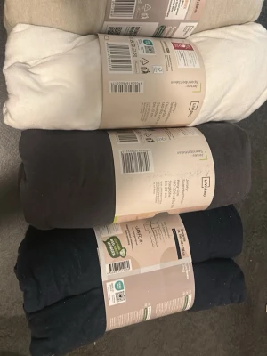 Fyra lakan i olika färger från Livarno - Säljer fyra stycken dra-på-lakan från Livarno i färgerna beige, vit, mörkgrå och mörkblå. Lakanen är tillverkade i bomull och har resår runtom för enkel användning. Perfekta för enkelsängar och ger en stilren känsla till sovrummet.