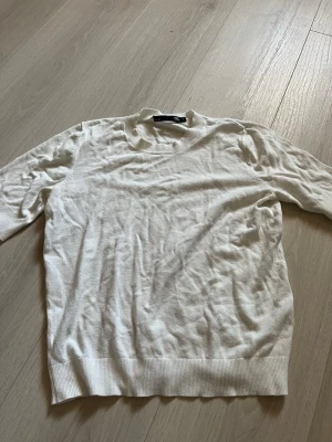 Vit stickad tröja från H&M - Klassisk vit stickad tröja  med rund halsringning och ribbade muddar vid ärmslut och nederkant. Tröjan har en enkel och stilren design som passar till det mesta. Perfekt basplagg för garderoben.