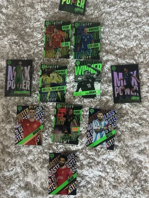 Samling fotbollskort Topps - Säljer en samling fotbollskort från Topps med olika spelare och teman som Max Power, Impact, Winner, Electric och Masterclass. Korten har färgstarka designer med spelarbilder och text i neonfärger. Perfekt för dig som gillar fotboll och samlarkort.