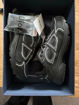 Dior B30 - Snygga svarta sneakers från Dior med vita kontrastdetaljer och klassisk snörning. Skorna har en chunky sula och är tillverkade i en mix av syntet och skinn. Perfekta för dig som vill ha en stilren och exklusiv look. Kontakta för frågor, pris är inte huggit i sten 👍🔥