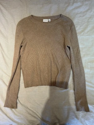 Beige ribbstickad tröja VILA - Snygg beige ribbstickad tröja från Vila med rund halsringning och långa ärmar. 