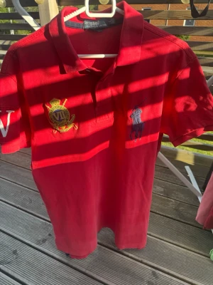 Röd piké från Polo Ralph Lauren - Tjena jag säljer en stilren röd raulph lauren piké som har den klassiska polo piké loggan och som är perfekt nu till sommaren när man vill tunna kläder men se riktigt fräsch ut/om du har några frågor angående mått eller något annat ställ dom så får du ett svar😊