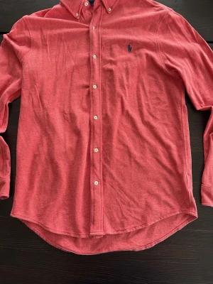 Röd skjorta från Ralph Lauren - Klassisk röd skjorta från Ralph Lauren i mjuk bomull.  Pris kan diskuteras 🟥🟥🟥🟥Skjortan har button-down krage, vita knappar framtill och den ikoniska broderade loggan på bröstet. Långärmad modell med normal passform, perfekt till många olika stilar.