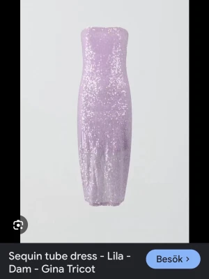 Lila paljettklänning från Gina Tricot - Trendig lila tubklänning från Gina Tricot, täckt med glittriga paljetter. Klänningen är axelbandslös och har en figurnära passform som ger en snygg siluett. Perfekt för dig som vill sticka ut med en glittrig look🪩💜✨ Den har dragkedja samt slits baktill och gummiresår vid bysten så att den sitter stabilt och inte glider ner. Aldrig kommit till användning tyvärr.