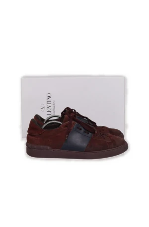 Valentino Garavani vinröda sneakers - Snygga sneakers från Valentino Garavani i vinrött mocka med mörkblåa detaljer på sidan. Skorna har klassisk låg profil, rund tå och matchande vinröda skosnören. Perfekta för dig som vill ha en stilren och exklusiv look. Som man kan se på sista bilden är det en liten slitning i hälen.
