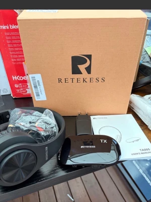 Retekess trådlösa hörlurar med sändare - Säljer ett par svarta trådlösa hörlurar från Retekess med tillhörande sändare och laddare. Hörlurarna har en modern, rund design och är tillverkade i plast med mjuka öronkuddar. Perfekt för dig som vill ha frihet utan sladdar.