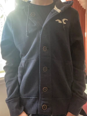 Mörkblå hoodie från Hollister - Säljer denna snygga unika blåa hoodien från Hollister. Modellen är 174| 65kg och bät storlek S Skriv vid frågor✨