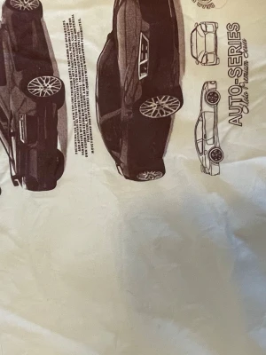 Vit t-shirt med biltryck Auto-Series - Säljer en vit t-shirt med coolt bilmotiv och texten 'Auto-Series' på framsidan. Trycket visar flera sportbilar i svart och grått, perfekt för dig som gillar bilar och streetstyle. Klassisk passform och rund hals, riktigt snygg till jeans eller shorts.