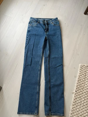 Blå raka jeans från Bik Bok - Snygga blå jeans från Bik bok med rak passform och klassisk femficksdesign. Jeansen har normal midja och dragkedja med knapp framtill. Perfekta för en avslappnad och trendig look.Jag är cirka 172 cm men kan också sys upp. 