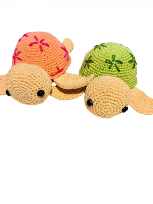 Två handvirkade Amigurumi-sköldpaddor - Handgjorda: Virkade av mig (Amigurumi-teknik). Material: 100% högkvalitativt bomullsgarn som ger en fin textur och hållbarhet. Fyllning: Mjuk och allergivänlig polyestervadd. Detaljer: Söta broderade blommor på skalet och säkra ögon.