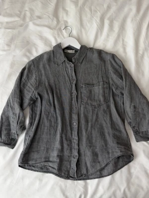 Grå skjorta - Grå tunn skjorta från Zara som passar perfekt nu när det börjar bli varmare 🤍 har lite kortare armar (trekvarts) bra skick förutom en liten röd prick vid armen som inte går bort (se sista bilden) men syns inte vid användning 🤍