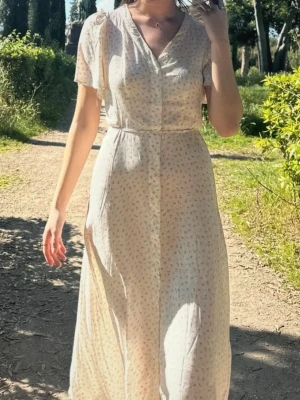 Blommig klänning  - Blommig långklänning från Vero Moda, så skönt material! Bandet i midjan går att ta av. Använd 2 gånger därmed superfint skick!🌸 Jag är 178 för referens!