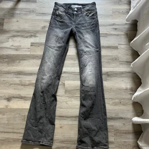  svarta bootcut jeans - Säljer ett par svarta jeans med bootcut passform. Klassisk femficksmodell med knapp och dragkedja fram. Jeansen har en snygg tvättad look och är tillverkade i slitstarkt denim. Perfekt för dig som gillar retrostil och vill ha ett par jeans med lite extra attityd.