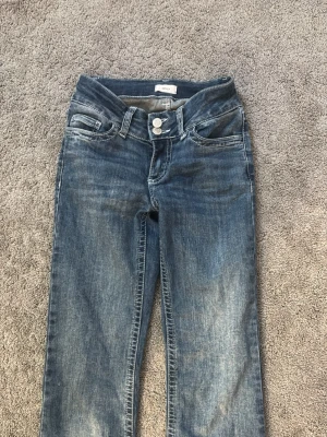 Blåa jeans med dubbla knappar - Jeans från Nelly, knappt andvända, storlek XXS men passar som XS