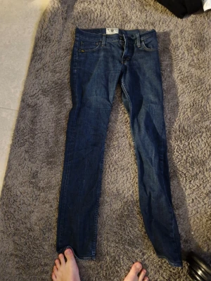 Mörkblå skinny jeans från Cheap Monday - Säljer ett par mörkblå skinny jeans från Cheap Monday med klassisk femficksdesign och låg midja. Jeansen har smal passform och är tillverkade i stretchigt denimtyg för extra komfort. Perfekta för en avslappnad och trendig look.