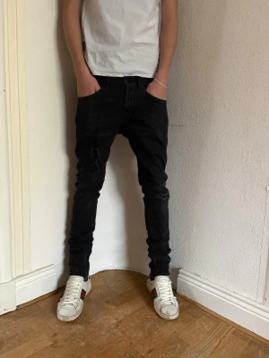 Svarta skinny jeans från Dondup - Svarta jeans från Dondup i skinny fit-modell. Snyggt smal passform med klassiska fem fickor och knappgylf. Materialet är jeans och färgen är helsvart, vilket ger en stilren look. Märkta med Dondup och George Skinny Fit på insidan. Priset kan diskuteras vid snabb affär 