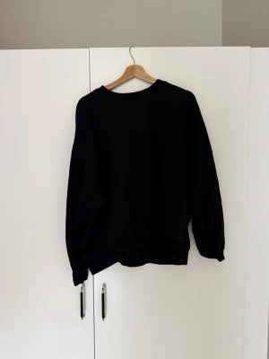 Svart oversized hoodie weekday - En  svart oversized hoodie från weekday med rund hals och långa ärmar. Hoodien har en avslappnad passform och är tillverkad i mjukt material. Storlek M. Bra skick.