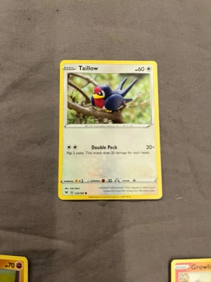 Pokémonkort Taillow - Säljer ett Pokémonkort med Taillow, en fågel med blå kropp och röd ansikte. Kortet har gul ram och motivet visar Taillow sittande på en gren. Kortet har attacken Double Peck och är på engelska.