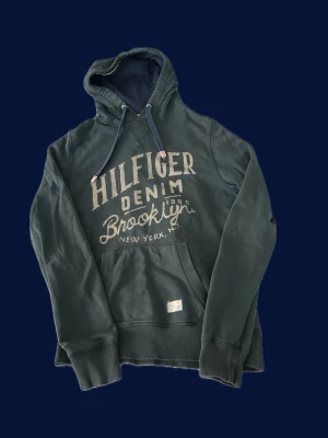 Grön Hilfiger Denim hoodie Brooklyn - Skön hoodie från hilfiger denim. Storlek M men kan passa större, modellen på bild är 180 cm. Hör av er vid minsta fundering!