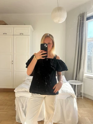 Svart offshoulder blus med volang💖💖 - Trendig svart offshoulder blus med bred volang runt axlarna. Blusen har en luftig passform och tunna axelband. Perfekt att matcha med ljusa byxor för en snygg kontrast. Materialet ser ut att vara lätt och bekvämt, perfekt för varmare dagar.