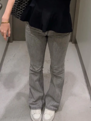 Grå bootcut jeans från Nelly - Säljer ett par grå bootcut jeans från Nelly med klassiska svarta sömmar på bakfickorna. Sparsamt använda och inga defekter.