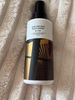 Lyko Beat The Heat Multi Spray - Lyko Beat The Heat Multi Spray är en värmeskyddande spray med arganolja som ger volym och glans till håret. Flaskan är vit med svart och guldigt grafiskt mönster och rymmer 150 ml. Perfekt för dig som vill skydda håret vid styling med värmeverktyg. Använt fåtal gånger. Ca 100ml kvar.. ish 💛liten extra gåva vid varje köp! Skickar allt omsorgsfullt i bubbelplast & kartong