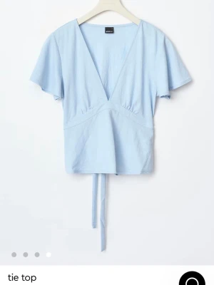 Ljusblå topp med knytband - Snygg ljusblå topp, använd en gång så den är i välldigt bra skick. 