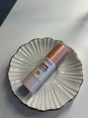 L'Oréal Lumi Le Gloss highlighter stick - Krämig highlighter i stickformat från L'Oréal, Lumi Le Gloss. Färgen är en skimrande champagne-ton som ger glow till huden. Enkel att applicera tack vare den rundade formen och smidig att ta med i väskan. Perfekt för att framhäva kindben och ge lyster. Pris kan diskuteras, aldrig använt!