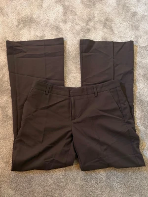 Bruna kostymbyxor Gina Tricot  - Jättefina bruna kostymbyxor från Gina Tricot i modellen Relaxed bootcut, oanvända. I storlek 40 passar M/L💞