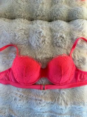 Intimissimi BH - Säljer en helt oanvänd Intimissimi bh i storlek 75B. Vacker korallrosa färg med fina spetsdetaljer och ett elegant guldfärgat spänne i mitten som ger en lyxig touch.  I nyskick utan defekter. Denna produkt säljs inte längre🩷  Hör av dig vid frågor!☺️