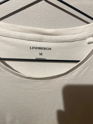 Vit t-shirt från Lindbergh  - Klassisk vit t-shirt från Lindbergh  med rund halsringning och normal passform. Tillverkad i mjuk bomull som känns skön mot huden. Perfekt basplagg för alla tillfällen och enkel att matcha med andra plagg.
