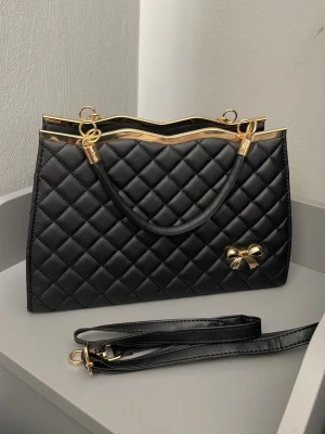 Handväska/axelremsväska  - Säljer en fin väska i en bra kvalitet som inte har används. Väskan kommer med en axelrem som man kan sätta fast i väskan. Väskan har flera fack