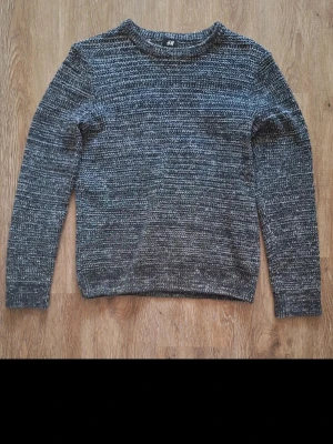 Stickad tröja - Snygg gråmelerad stickad tröja från H&M med rund halsringning och långa ärmar.. Perfekt för lager på lager och enkel att matcha.