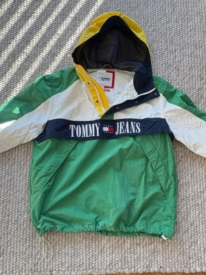Flerfärgad vindjacka Tommy Jeans - Snygg vindjacka från Tommy Jeans i grönt, vitt, gult och marinblått. 