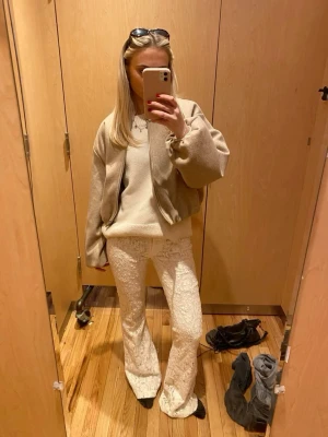 Vita spetsbyxor med bootcut - Unika vita byxor i spetsmaterial med bootcut-modell. Byxorna har en snygg, figurnära passform upptill och släpper ut nedtill för en trendig siluett. Perfekta för dig som vill sticka ut med en cool och feminin look.