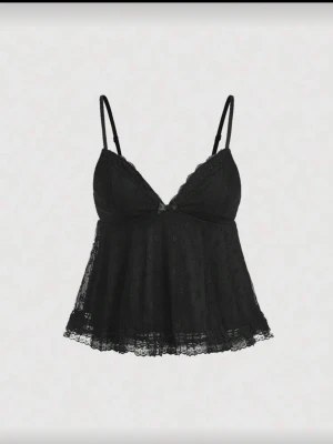 Svart spetsbody med tunna axelband - Snygg svart body i spets med tunna justerbara axelband och v-ringning. Modellen har en lösare passform nedtill och fina spetsdetaljer längs kanterna. Perfekt för dig som gillar en feminin och trendig look.