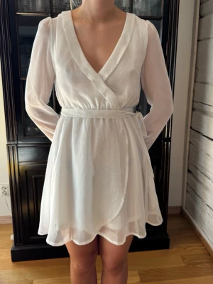 Vit klänning. Studentklänning. 34. Skir.  - Ny vit klänning. Perfekt till studenten. Skir omlottmodell. Dubbelt tyg i kjol o liv förutom i ärmarna. Storlek 34. Från Nelly, NLY Trend. Oanvänd. Lapparna kvar. Finns inget att anmärka på. NWT. 