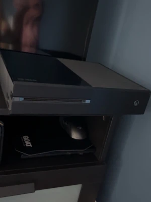 Xbox One microsoft  - Säljer en Xbox One i svart med en limegrön och vit handkontroll. Konsolen har en stilren, rektangulär design och är tillverkad i plast. Tre spel ingår: Star Wars Battlefront, Assassin's Creed Odyssey och Madden NFL 18. Perfekt för gamingkvällar! 