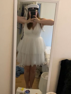 Vit studentklänning med volang - Supersöt vit kort klänning med v-ringning och dubbla volanglager i kjolen. Dragkedja i ryggen. Perfekt för student eller skolavslutning.     Använd 1 gång🤍 Storlek L. 