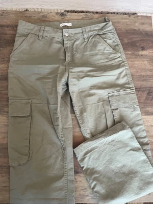 Beige cargobyxor med stora fickor - Snygga cargobyxor med raka ben och stora sidofickor. Byxorna har klassisk cargostil med flera praktiska fickor både fram och bak. 