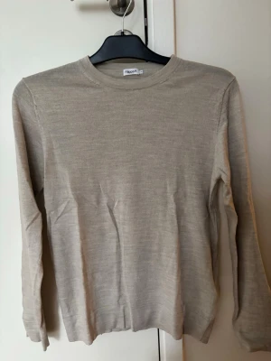 Beige stickad tröja Filippa K - Snygg beige stickad tröja från Filippa K i storlek XS. Tröjan har rund halsringning, långa ärmar och en tunn, mjuk kvalitet som passar perfekt till lager på lager. Enkel och stilren design som funkar till det mesta. Materialet är 100% ull