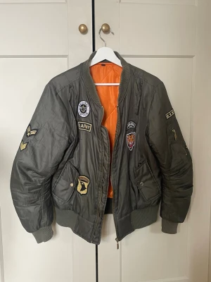 Olivgrön bomberjacka med patches - As ball bomberjacka! Bra skick, snygg passform