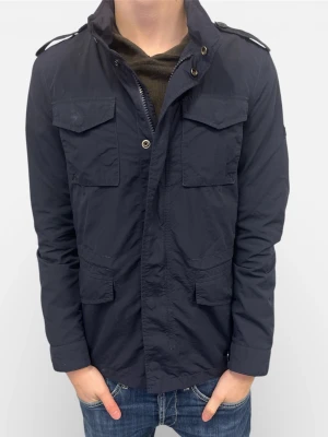 Blå Woolrich Fieldjacka  - Tja! Säljer nu denna eftertraktade fieldjacketen från Woolrich i blå. Se storlek nedan. Den är i ett mycket bra skick.                                                 Nypris: ca. 5000kr.                                                       Säljs för: 1099kr                                                                 Hör gärna av er vid intresse eller frågor! 