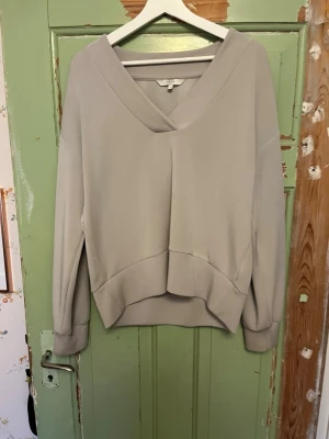 Grå tröja - Snygg ljusgrå tröja med bred V-ringning och långa ärmar. Storlek M. Hör av er om bilder, priset kan alltid diskuteras! 