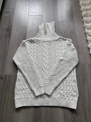 Ljusgrå kabelstickad  - Säljer denna snygga hoodien till super bra pris. Den passar till allt. Jag skulle säga att de är storlek M. Väldigt fint skick. Hör av dig vid intresse!
